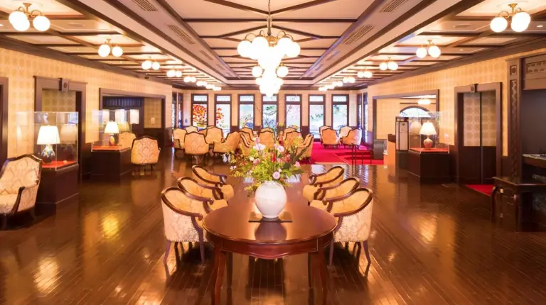 a hotel lobby with a table and chairs and a room at Kanazawa Hakuchoro Hotel Sanraku -Natural Hot Spring- in Kanazawa
