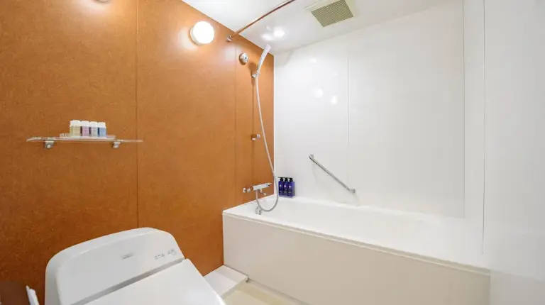 a bathroom with a white toilet and a shower at Kanazawa Hakuchoro Hotel Sanraku -Natural Hot Spring- in Kanazawa