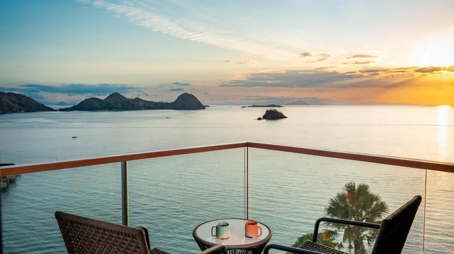 a view of the ocean from a balcony with chairs and a table at Katamaran Hotel & Resort Komodo in Labuan Bajo