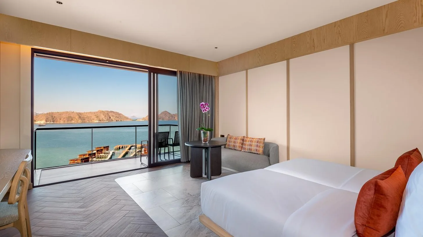 a bedroom with a bed and a view of the ocean at Katamaran Hotel & Resort Komodo in Labuan Bajo