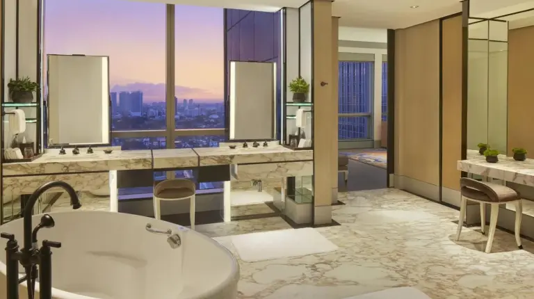 a bedroom with a large bed and a couch at Keraton At The Plaza
