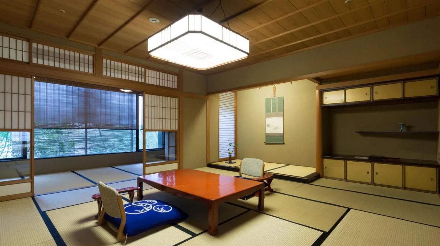 a large room with a table and chairs and a television at Kinjohro in Kanazawa
