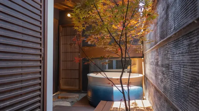 a bath tub sitting on a porch with a tree at Kiraku Kyoto Gion in Kyoto