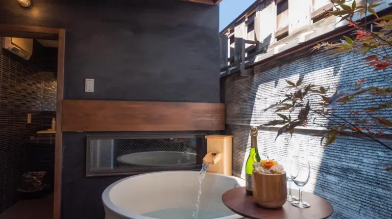 a bathroom with a bath tub and a fireplace at Kiraku Kyoto Gion in Kyoto