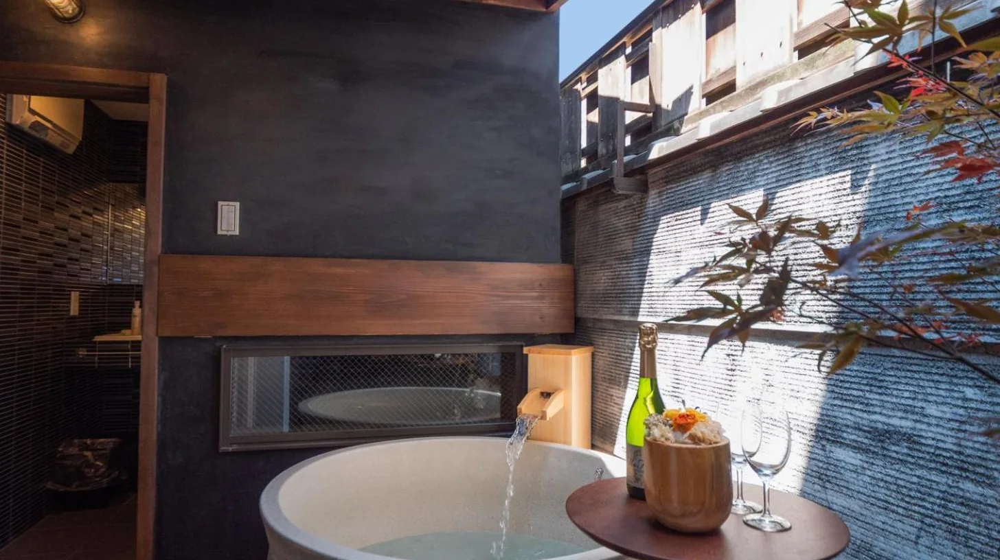 a bathroom with a bath tub and a fireplace at Kiraku Kyoto Gion in Kyoto