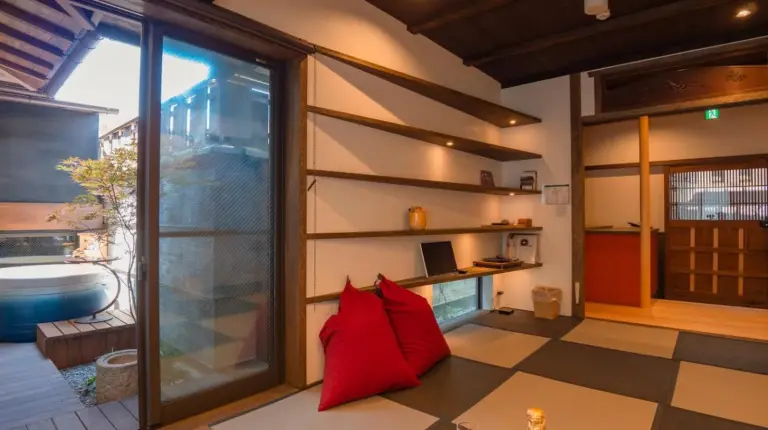 a living room with a red pillow on the floor at Kiraku Kyoto Gion in Kyoto
