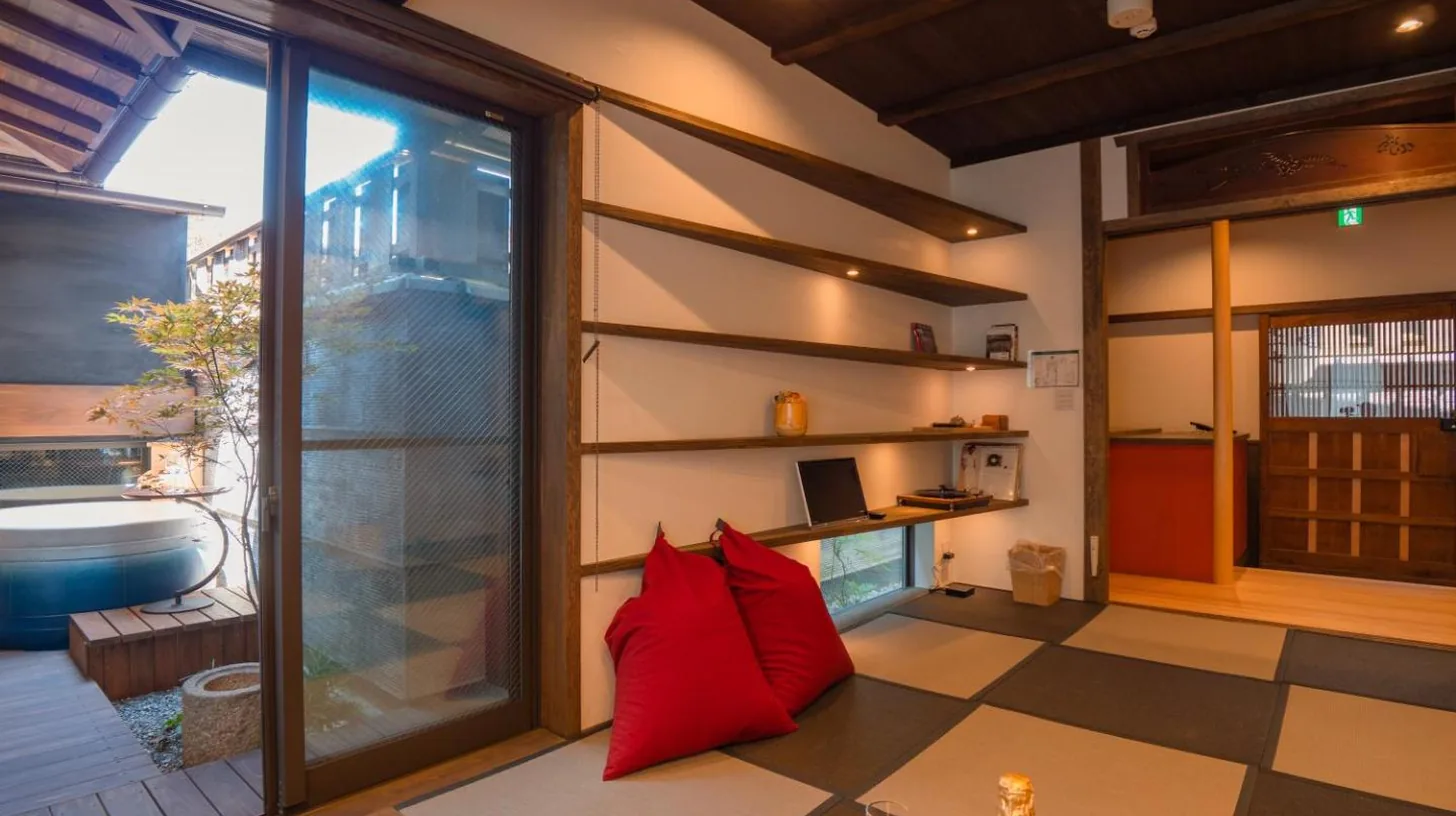 a living room with a red pillow on the floor at Kiraku Kyoto Gion in Kyoto