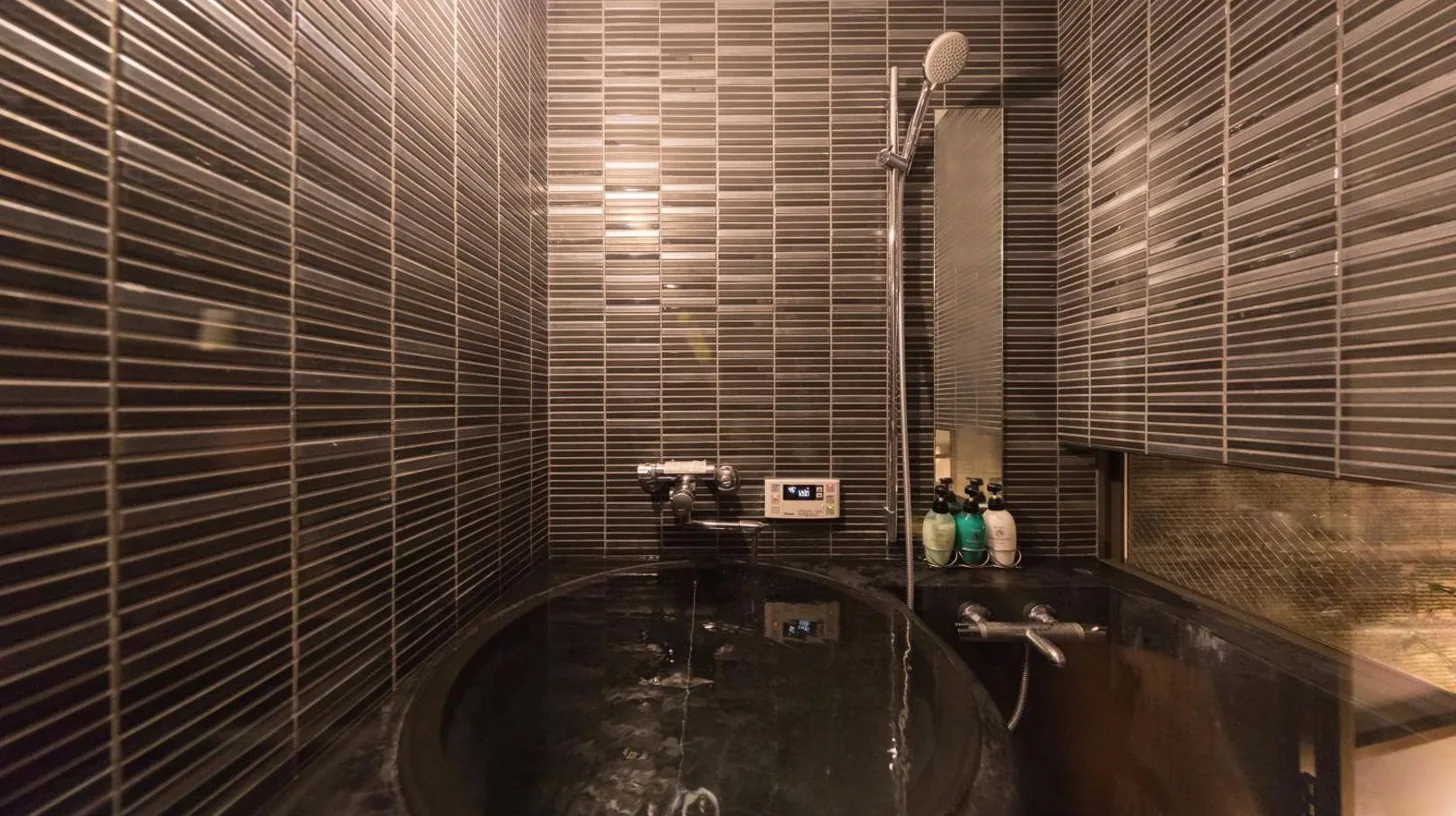 a bathroom with a black tub in a room at Kiraku Kyoto Gion in Kyoto