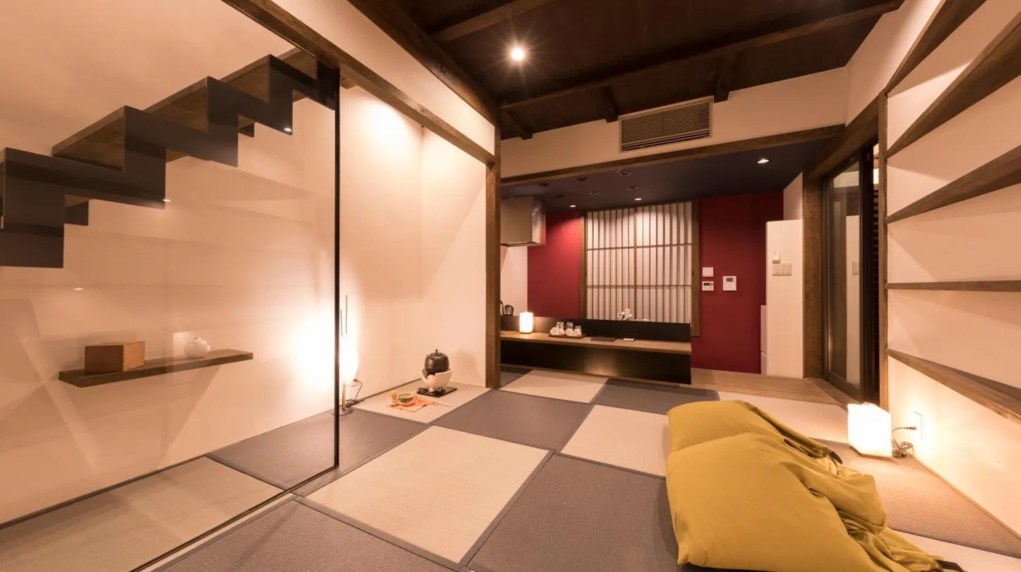 a living room with a staircase and a yellow couch at Kiraku Kyoto Gion in Kyoto