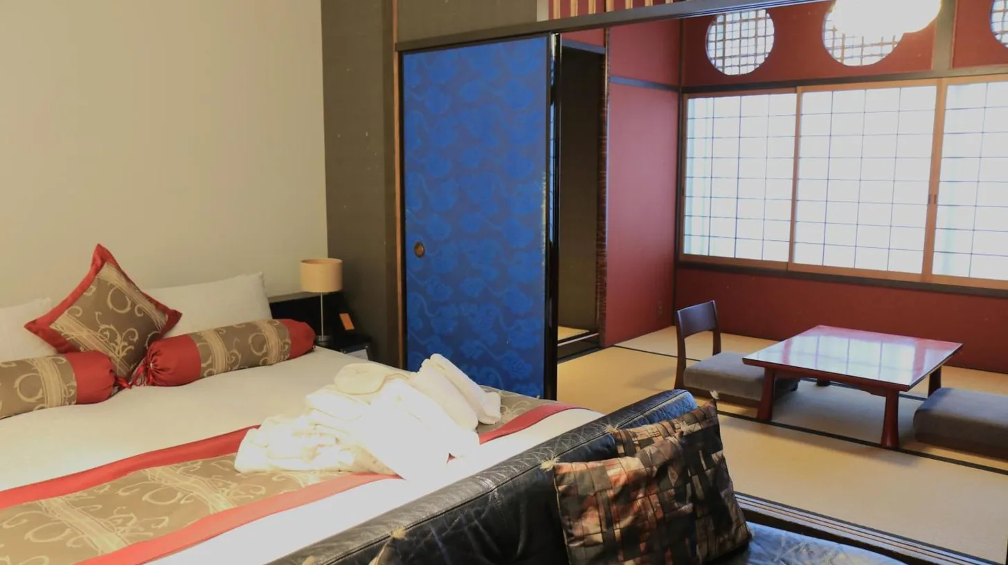 a room with a bed and a couch and a table at Kizashi The Suite Kyoto Gion in Kyoto