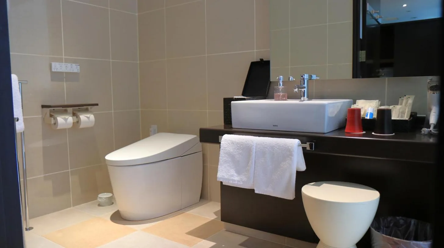 a bathroom with a sink and a toilet and a mirror at Kizashi The Suite Kyoto Gion in Kyoto