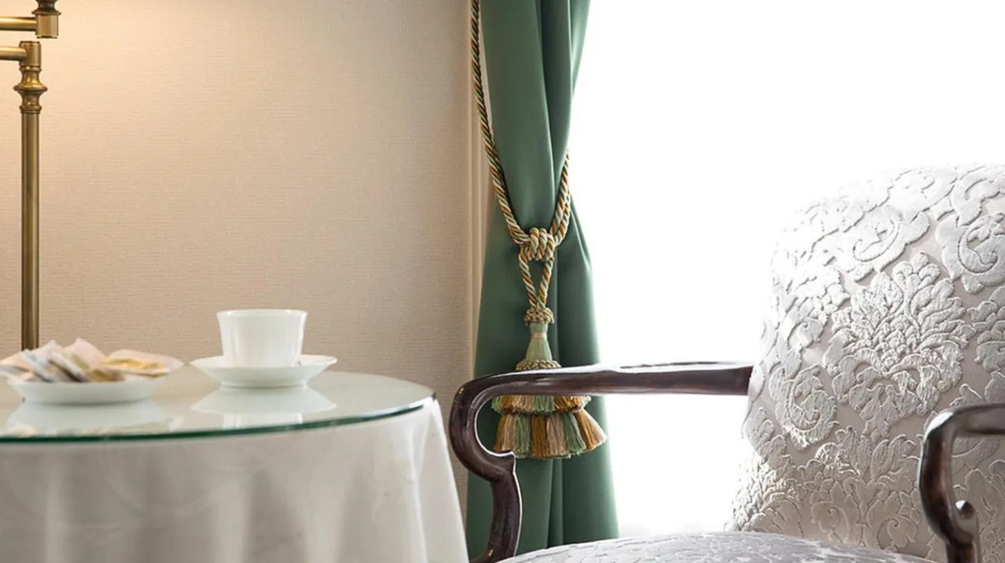 una mesa con una taza de café y una silla en Kobe Kitano Hotel en Kobe