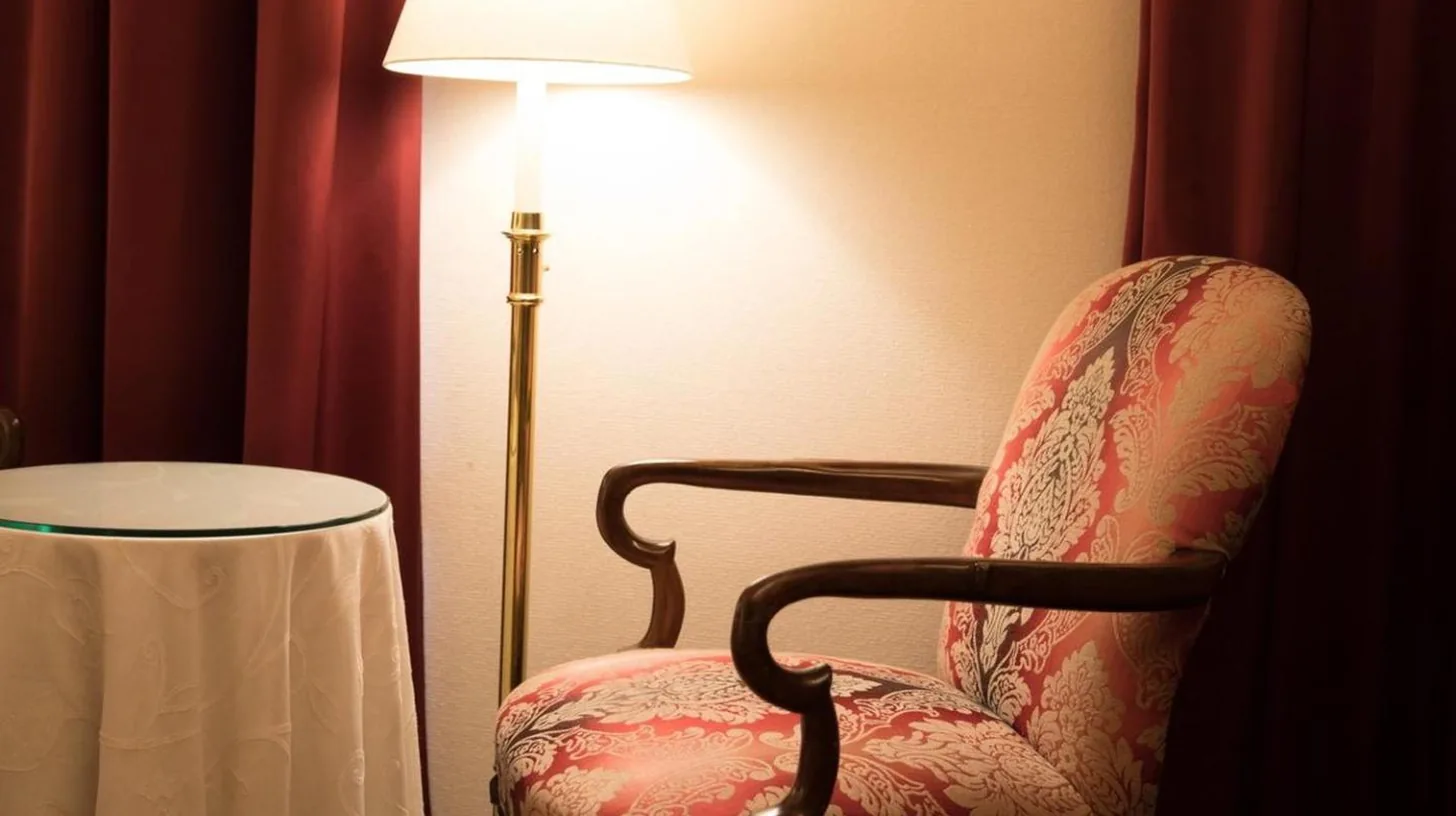 una silla al lado de una lámpara en una habitación en Kobe Kitano Hotel en Kobe