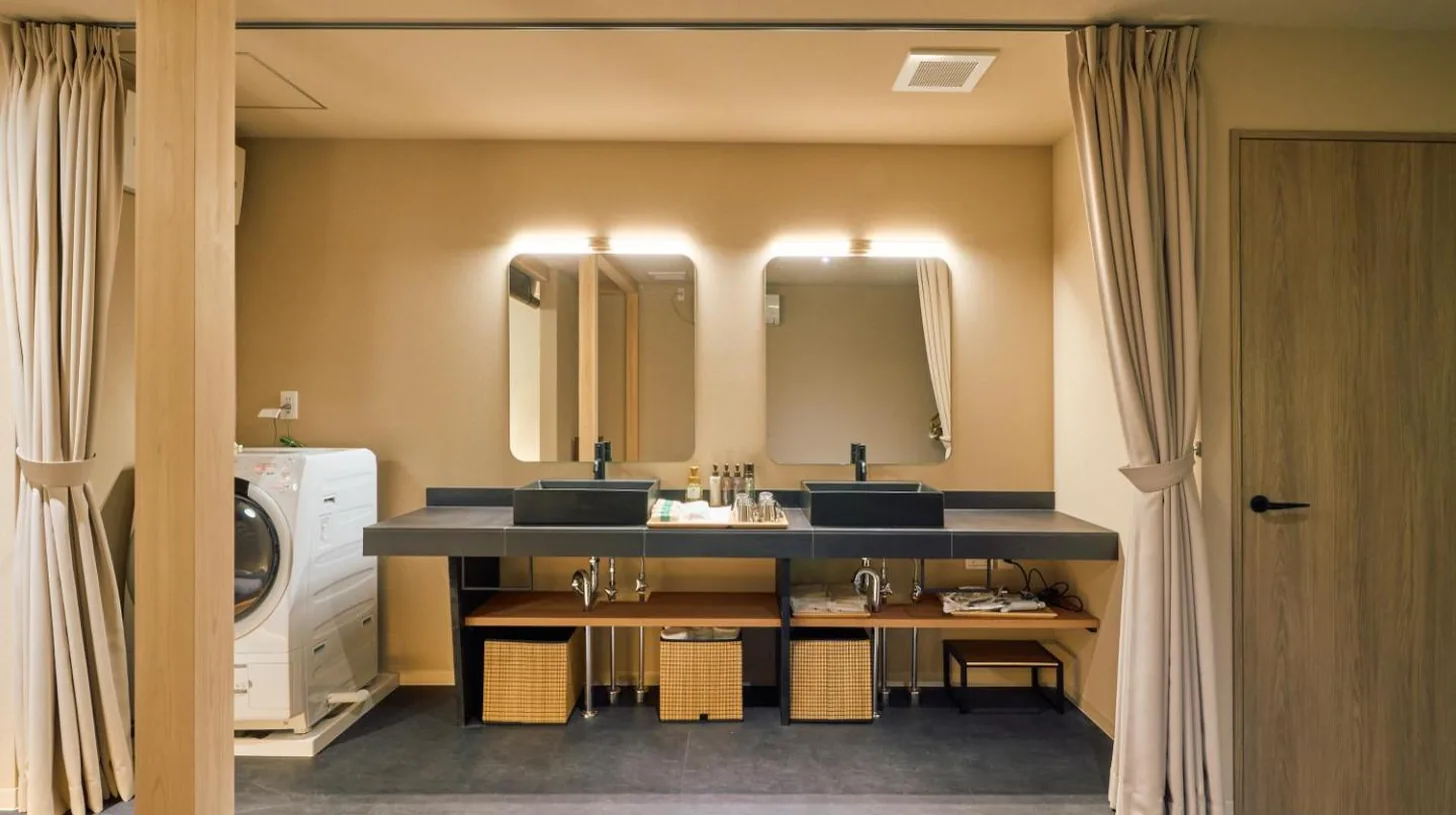 ein Badezimmer mit zwei Waschbecken und einer Waschmaschine bei KONJAKUSO OSAKA TSUTENKAKU MUSHIBUROYA Sauna Villa in Osaka