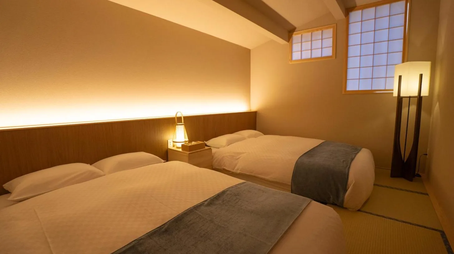 ein Schlafzimmer mit zwei Betten und Fenster bei KONJAKUSO OSAKA TSUTENKAKU MUSHIBUROYA Sauna Villa in Osaka