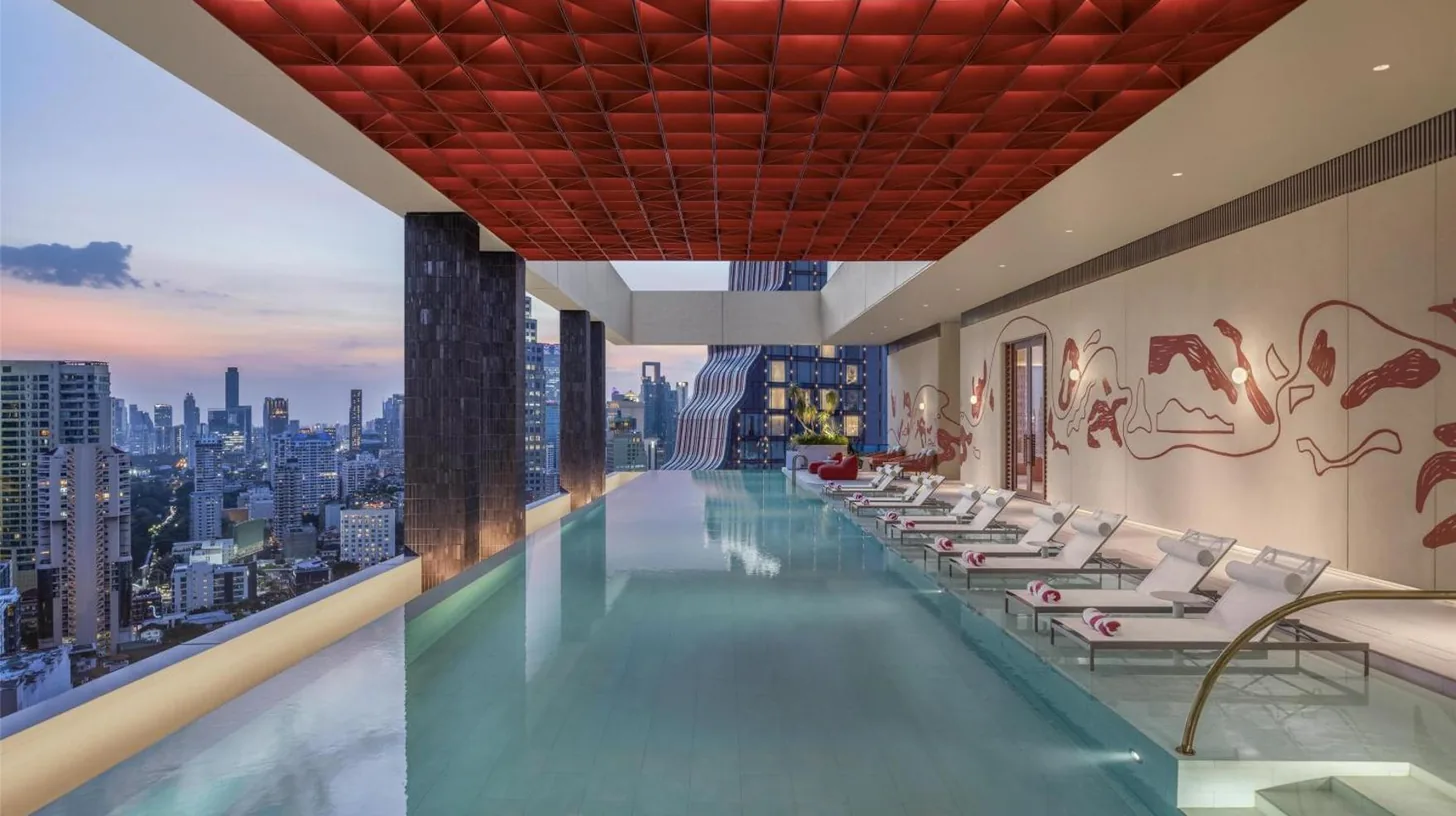 a pool in a hotel with a view of a city at Kromo Bangkok