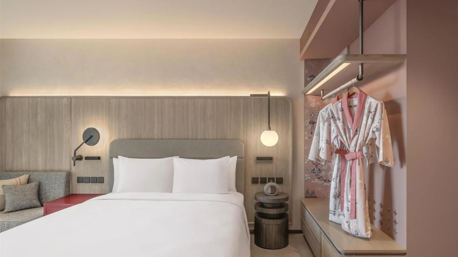 a bedroom with a large white bed and a table at Kromo Bangkok