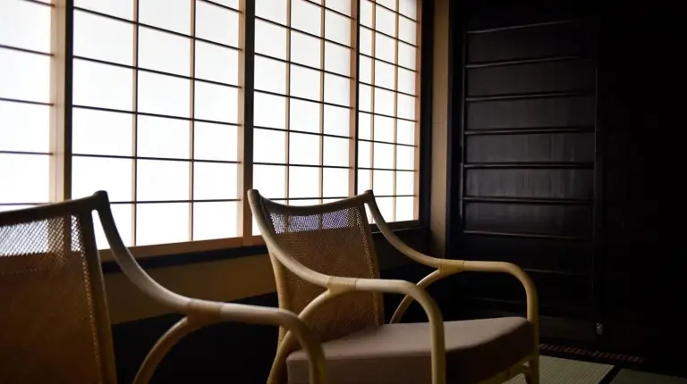 zwei Stühle in einem Zimmer mit großen Fenstern bei Kuraya Nanseicho in Kyoto