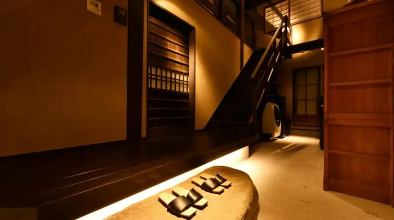 ein Wohnzimmer mit einer Couch in einem Zimmer mit Treppe bei Kuraya Nanseicho in Kyoto