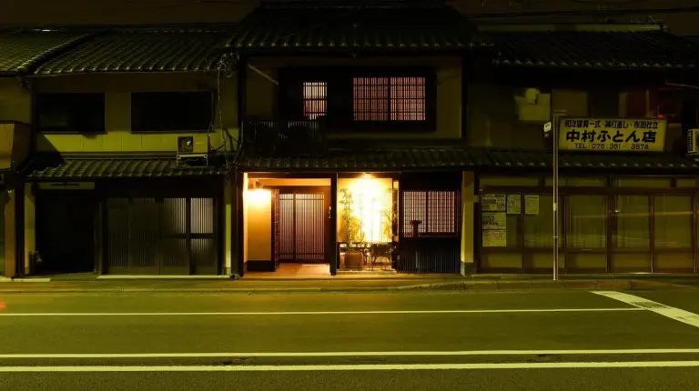 una calle vacía frente a un edificio de noche en Kuraya Omiya Shimabara en Kioto