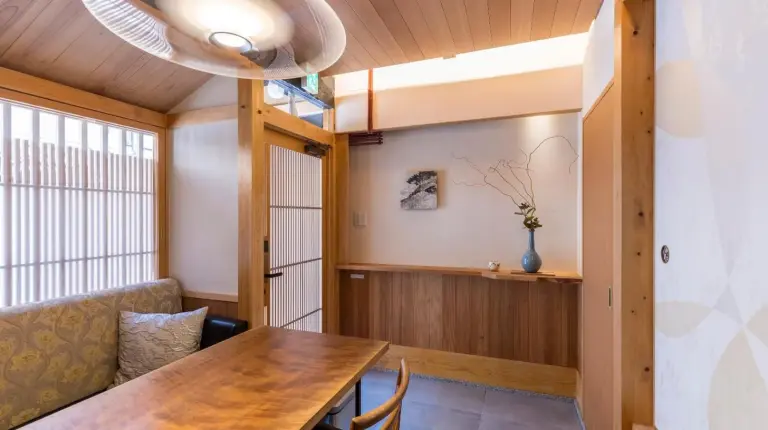 a dining room with a table and a couch at Kyomachiya Suite Rikyu in Kyoto