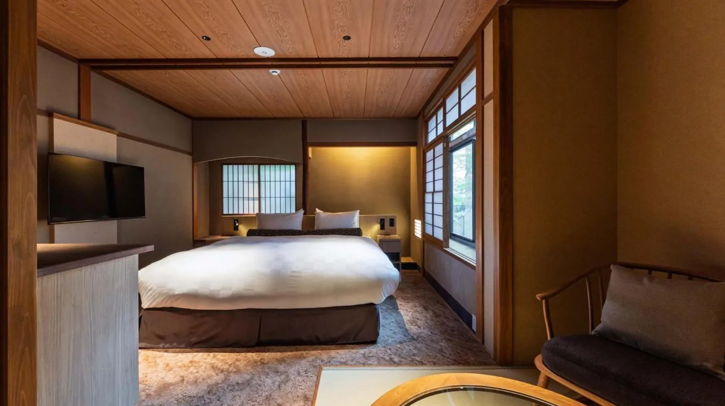 a hotel room with a bed and a tv at Kyoto Ryokan SAKANOUE in Kyoto
