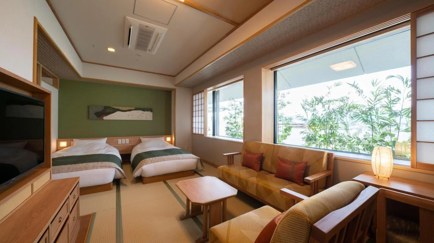 une chambre avec deux lits, un canapé et une télévision à Kyoto Umekoji Kadensho à Kyoto