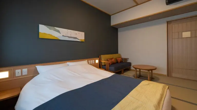 une chambre avec un grand lit et une chaise à Kyoto Umekoji Kadensho à Kyoto