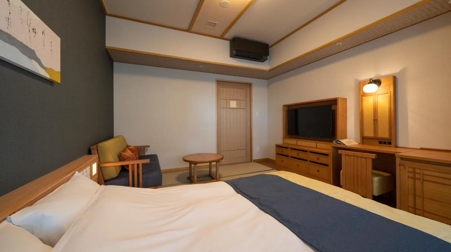 une chambre d’hôtel avec un lit et une télévision à Kyoto Umekoji Kadensho à Kyoto