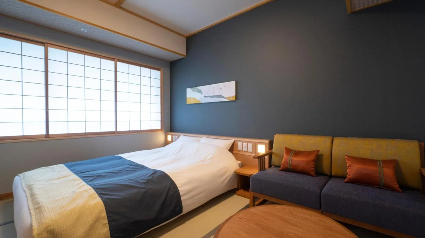 une chambre avec un lit et un canapé à Kyoto Umekoji Kadensho à Kyoto