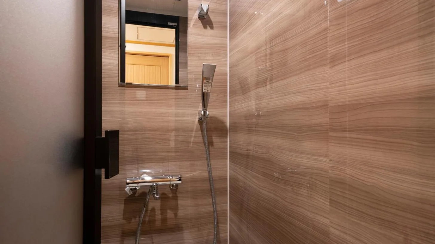 une salle de bain avec une douche et un miroir à Kyoto Umekoji Kadensho à Kyoto
