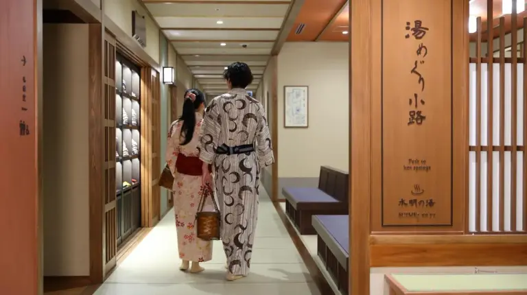 un homme et une femme en kimonos marchant dans un couloir à Kyoto Umekoji Kadensho à Kyoto