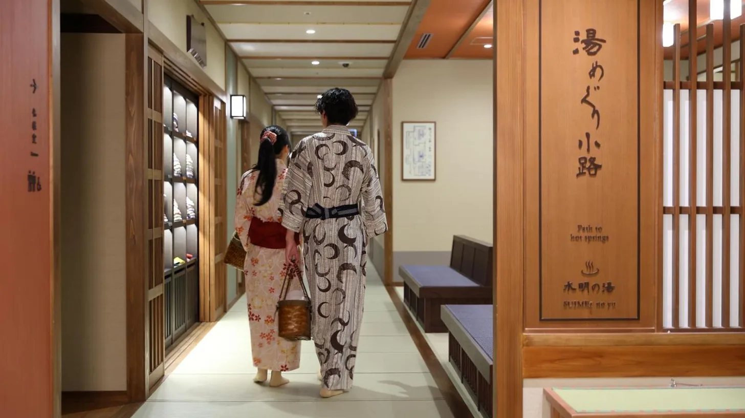 un homme et une femme en kimonos marchant dans un couloir à Kyoto Umekoji Kadensho à Kyoto