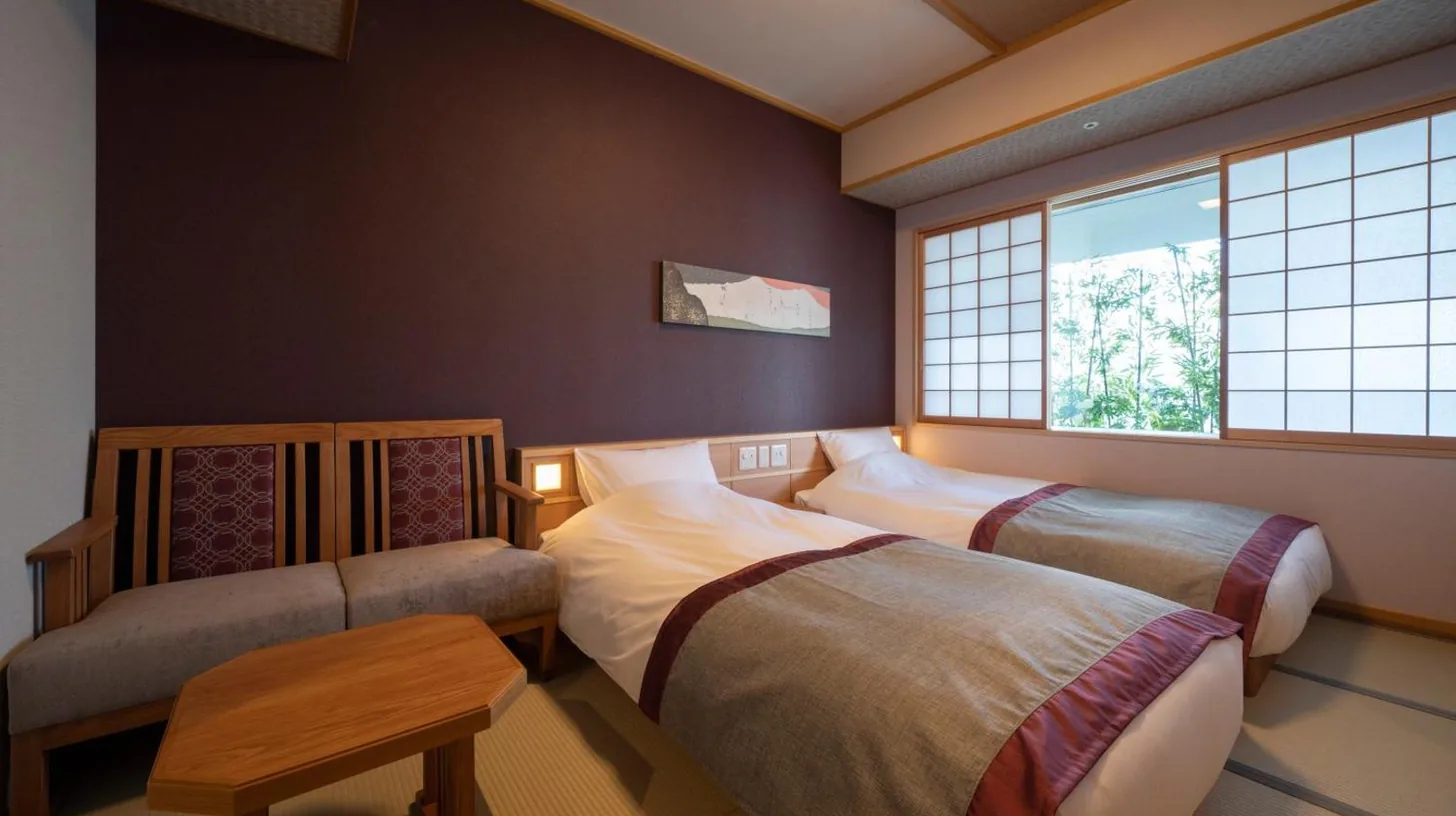 une chambre avec deux lits et une fenêtre à Kyoto Umekoji Kadensho à Kyoto