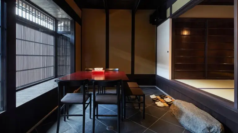 a table and chairs in a room with a window at Kyoto Urushiro Wakasaya in Kyoto