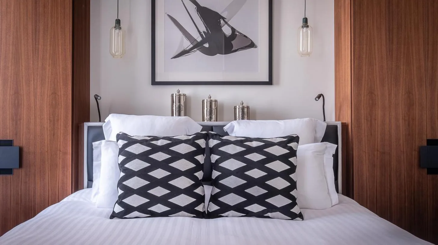 a bedroom with a bed with a black and white pillow at Le Boutique Hotel & Spa in Bordeaux