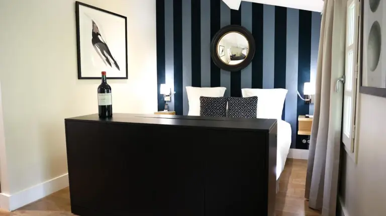 a bottle of wine on a dresser in a bedroom at Le Boutique Hotel & Spa in Bordeaux