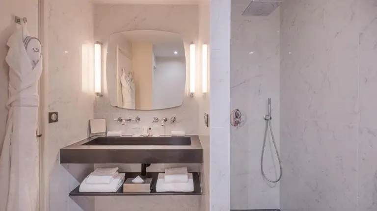 a white bathroom with a sink and a shower at Le Boutique Hotel & Spa in Bordeaux