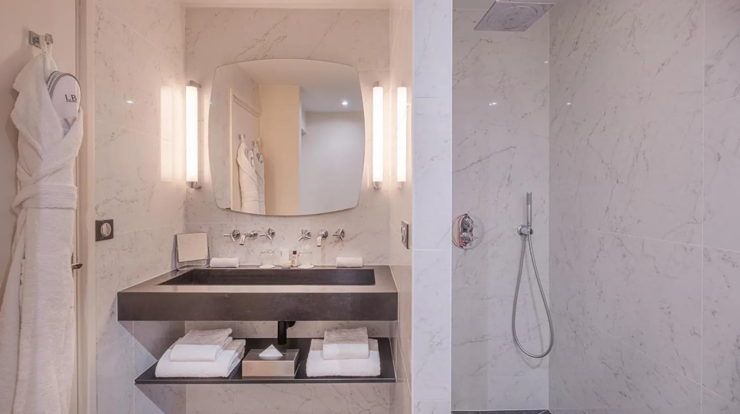a white bathroom with a sink and a shower at Le Boutique Hotel & Spa in Bordeaux