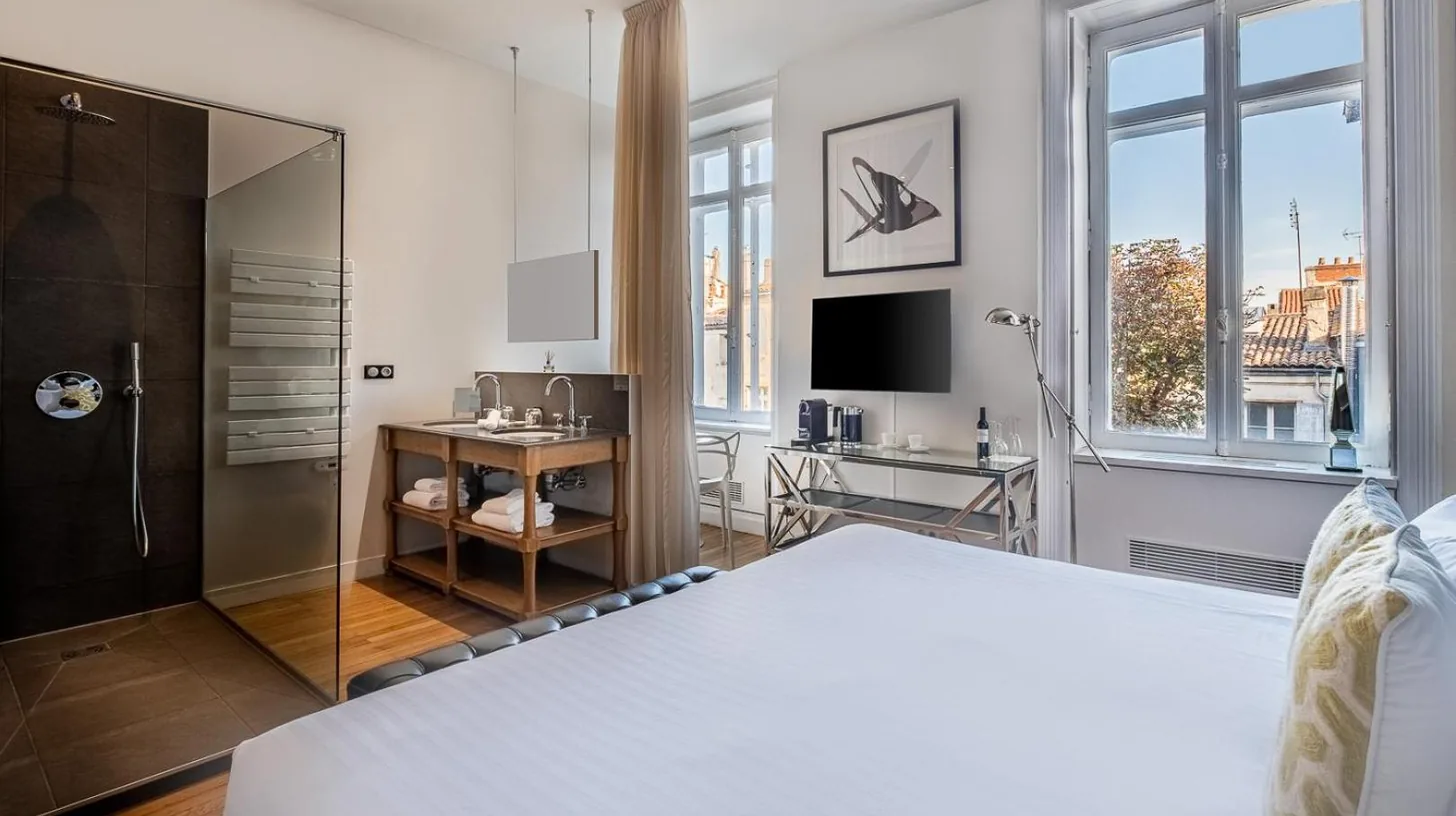 a bedroom with a large white bed with a window at Le Boutique Hotel & Spa in Bordeaux