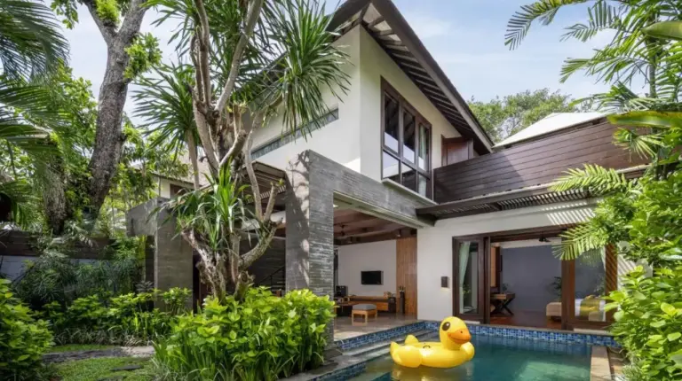 a pool in front of a house with a rubber duck in the yard at Le Jardin Villas Seminyak in Seminyak