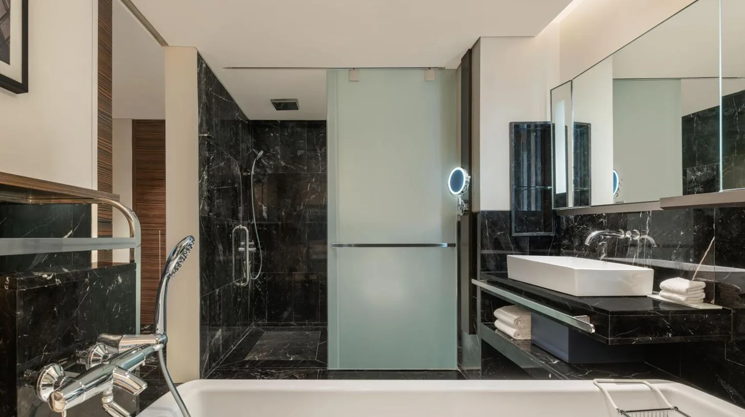 a bathroom with a tub and a sink and a shower at Le Meridien Bangkok in Bangkok