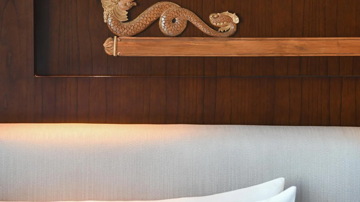 a wooden wall with a dragon above a bed at Le Meridien Jakarta in Jakarta