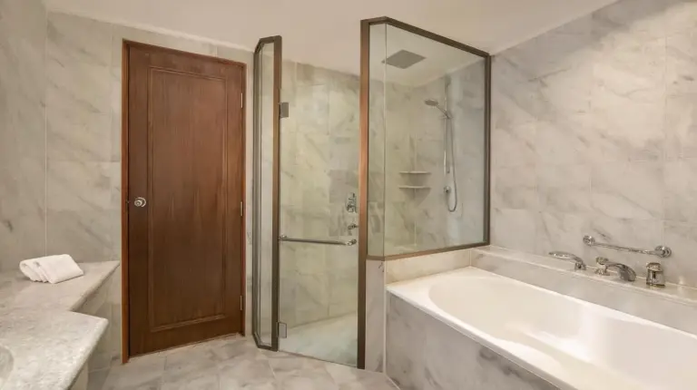 a bathroom with a shower and a tub and a sink at Le Meridien Jakarta in Jakarta