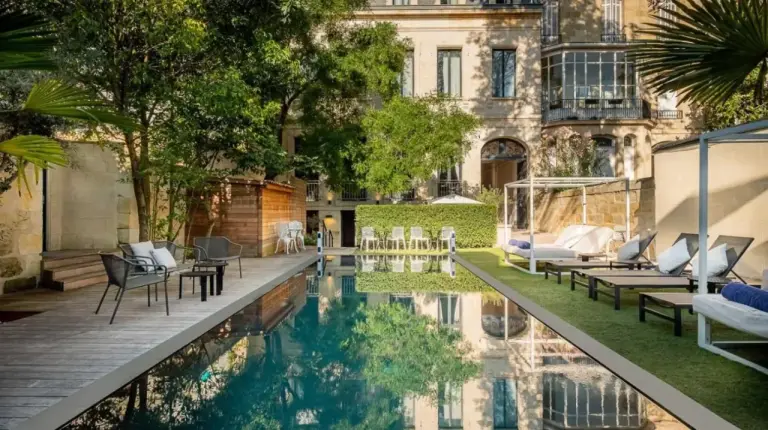 a courtyard with a pool in front of a building at Le Palais Gallien Hôtel & Spa in Bordeaux
