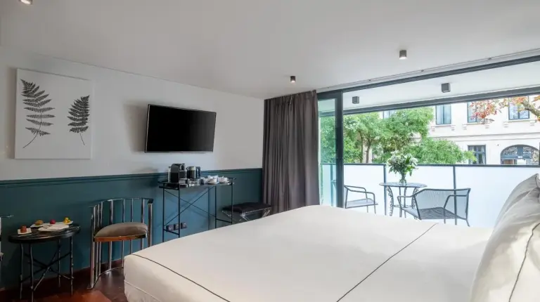 a bedroom with a large bed and a balcony at Le Palais Gallien Hôtel & Spa in Bordeaux