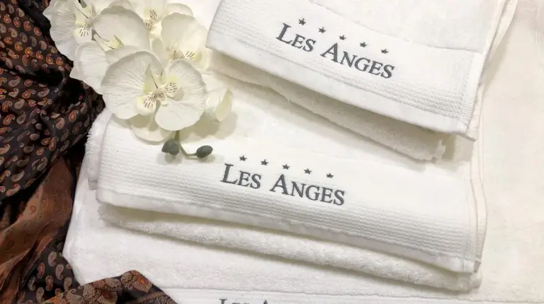 ein Stapel weiÃer HandtÃ¼cher mit Blumen darauf im Les Anges Deluxe in Avignon