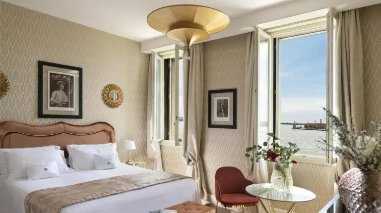 a bedroom with a bed and a large window at Londra Palace Venezia in Venice