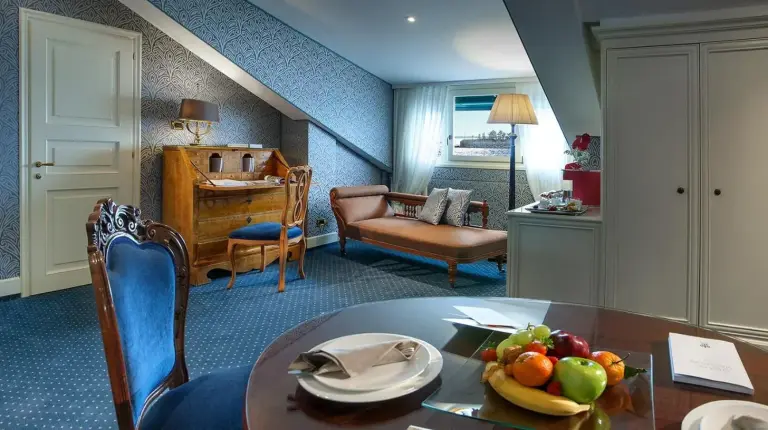 a bedroom with a bed and a table with a vase of flowers at Londra Palace Venezia in Venice