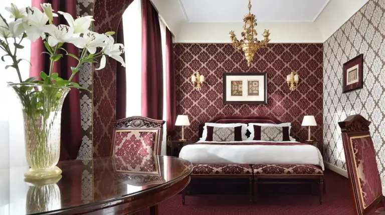 a hotel room with a bed and a table and a room at Londra Palace Venezia in Venice